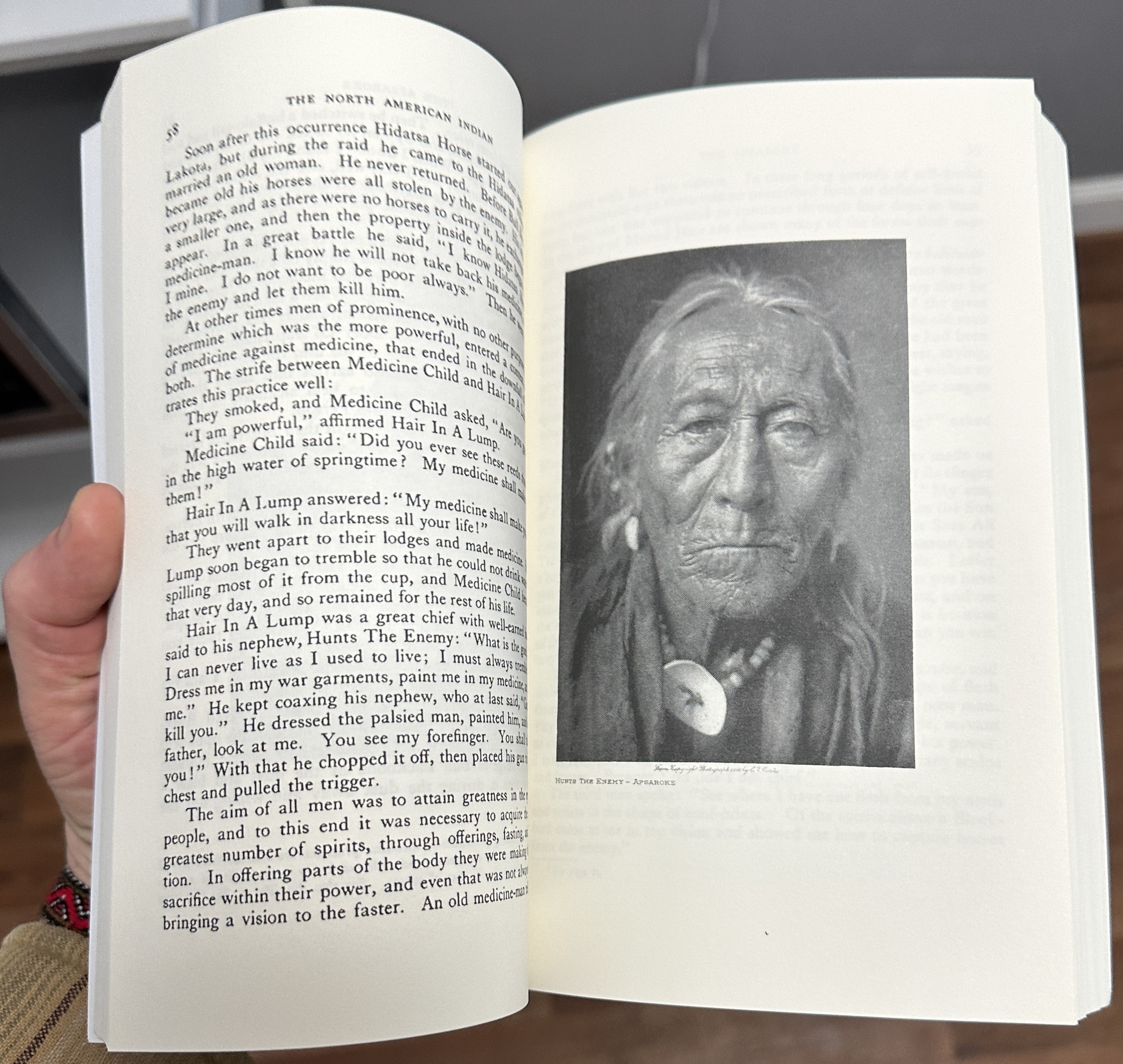 Close-up of an Edward Curtis paperback volume open to a page of text